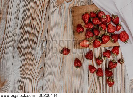 Juicy Red Strawberry Lies On The Wooden Board