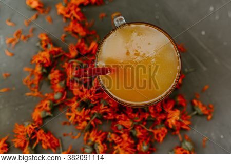 A Small Cup Is Filled To The Top With Yellow Liquid Honey, Orange Calendula.