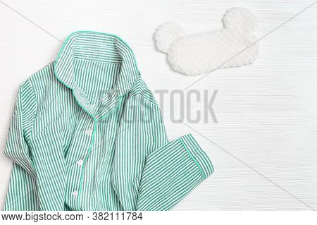 Sleepwear For Slumber. Women Neo Mint Colored Pajama With Stripes And Sleeping Mask On White Wood. C