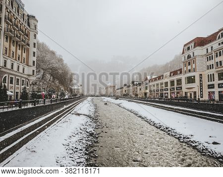 Sochi, Russia - 25 February 2020. River With Snow-capped Banks And European-style Buildings Along Th