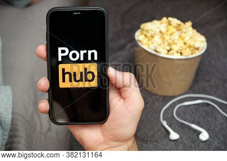 Close Up Mans Hand Holding A Mobile Phone With Porn Hub Logo With Apple Earphones And Popcorn Box Ne