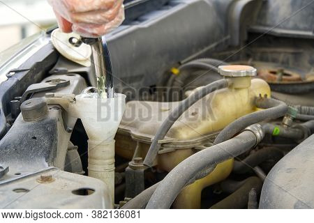 Adding Windshield Washer Fluid At Gasolin Station By Driver. Close-up Of Adding Windshield Washer Fl