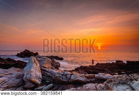 Brilliant Vivid Orange Sunrise Over The Ocean With Foreground Rocks In Various Textures And Stained 