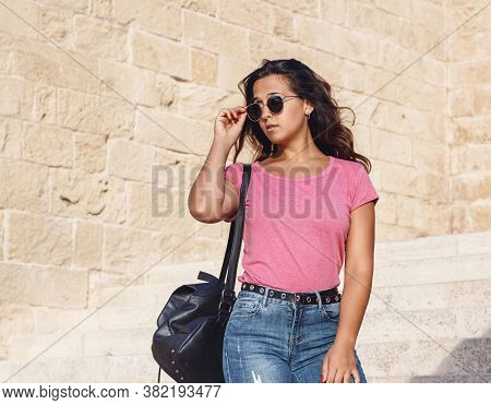 Young Women Going Down The Stairs And Touch  Sunglasses