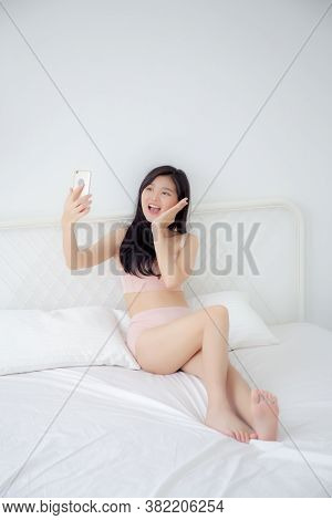 Beautiful Young Asian Woman Sexy In Underwear Talking A Selfie On Smartphone For Social Network In T