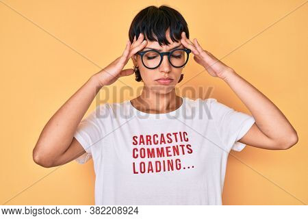 Beautiful brunettte woman wearing sarcastic comments loading t-shirt suffering from headache desperate and stressed because pain and migraine. hands on head. 