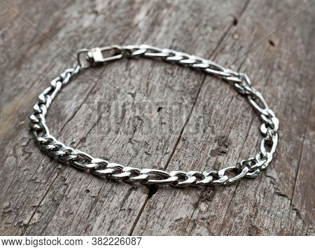 Women`s Wrist Bracelet Of Steel On Natural Wooden Background