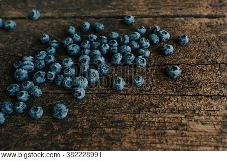 Blue Fresh Blueberries Are Scattered On An Wooden Table.