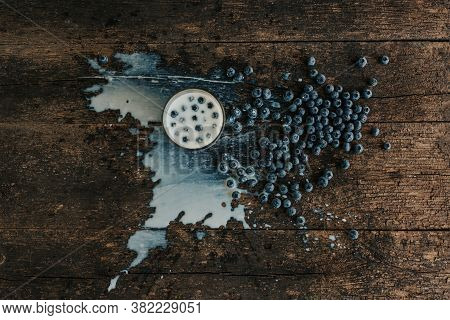 Berries Are Thrown Into The Transparent Glass Making Splashes Of Milk