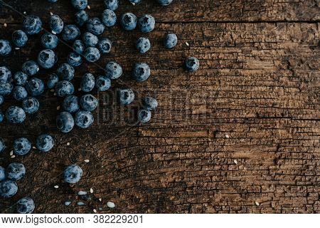 Blueberries Are Scattered On An Old Brown Wooden Cracked Table