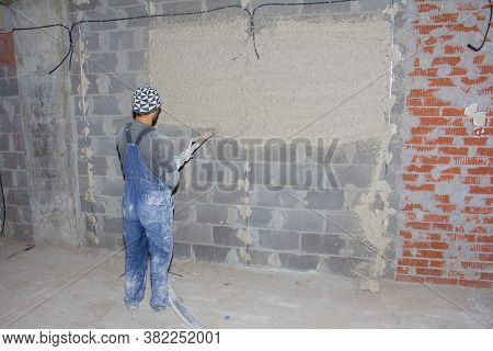 Machine Application Of Plaster To The Wall. Plasterer Spraying Plaster On Wall. Professional, Painti