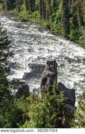 A Rock Pillar Stick Up Next To A Wild Section Ofhenrys Fork Of The Snake River Near Upper Mesa Falls