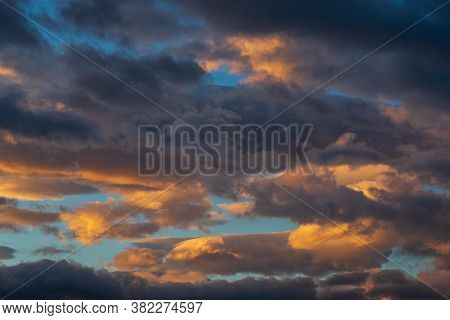 Stunning Colorful Thunderclouds In Blue Sky, Illuminated By Rays Of Sun At Sunset To Weather Change.