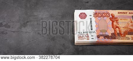 Russian Cash Banknotes Of Five Thousand Rubles, The Bundle Hangs On A Gray Background.