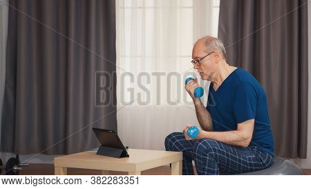 Senior Man Enjoying Working Out With Dumbbells During Online Fitness Program. Old Person Pensioner H
