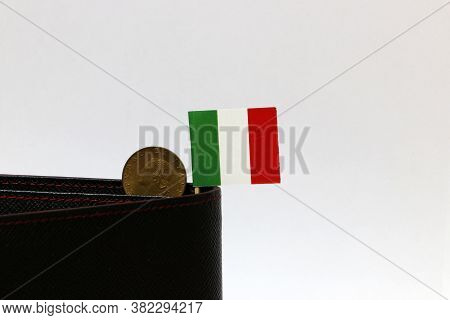 One Coin Of Italy Lire Money And Mini Italy Flag Stick On The Black Wallet With White Background. Re