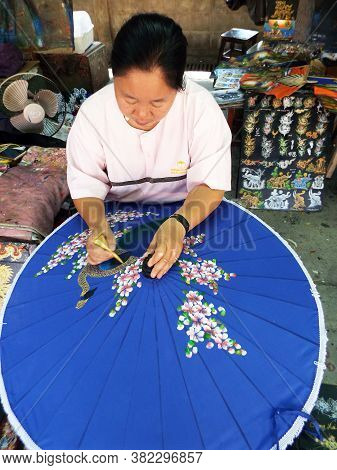 Bor Sang, Chiang Mai, Thailand, December 22, 2018: A Woman Colors An Umbrella At The Bor Sang Umbrel