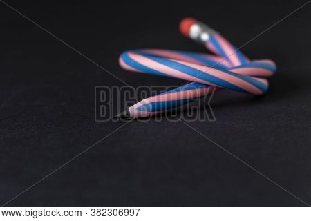 Flexible Pencil On A Dark Background. Selective Focus