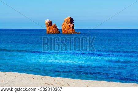 Orange Sea Stacks In Cea Beach On A Clear Day. Sardinia, Italy