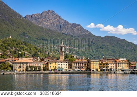 View Of City Of Porlezza On The Shore Of Lake Lugano With The Alps In The Background Seen From Lake,