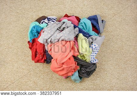 Pile Of Carelessly Scattered Clothes On Floor. Top View.