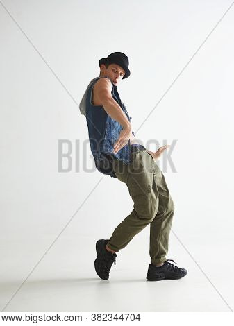 Stylish Young Guy Breakdancer In Hat Dancing Hip-hop In Studio Isolated On White Background. Break D