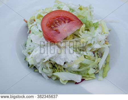 Feldkirch, Austria - July 26, 2020: A Plate Of Lettuce With Tomato And Yogurt Dressing