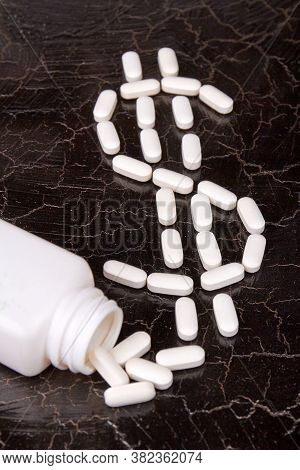 Dollar Sign Made Of Medicine Pills. Overturned White Medicine Bottle. American Healthcare Concept.