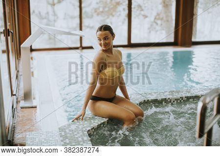 Young Woman Sitting And Relaxing By The Whirlpool Bathtub