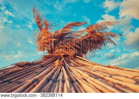 Straw Umbrella On Tropical Beach. Beautiful Sunrise With Clouds