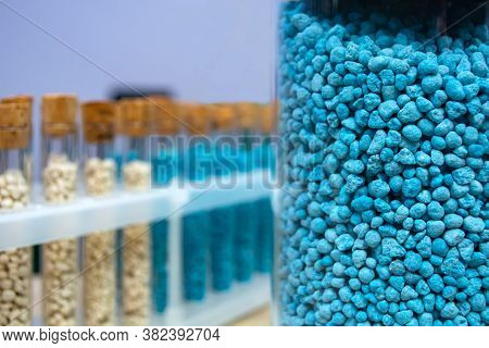 Multi-colored Granules Of Micronutrient Fertilizer In Test Tubes In A Row