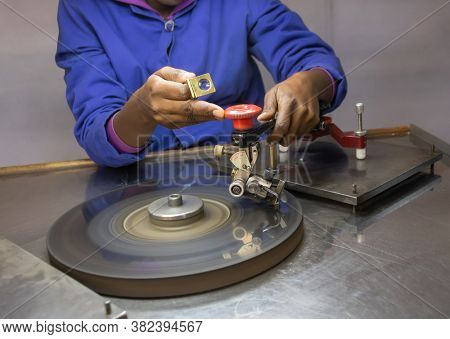 African woman working on a diamond at the polishing wheel, in a factory in Botswana