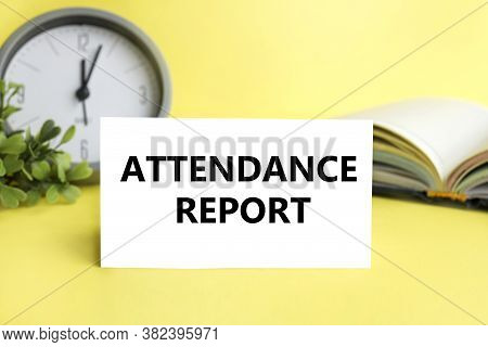 Attendance Report. Text On White Paper On A Yellow Background. Alarm Clock, Book On Background