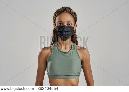 Think Of Your Health. Young Sportive Mixed Race Woman Wearing Black Protective Face Mask Looking At 