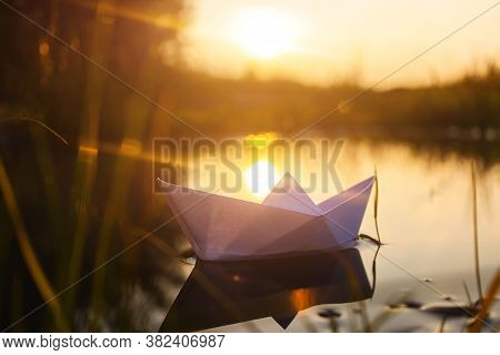 A Paper Boat Floats On The Water At Dawn. Creative Concept Of Outdoor Recreation, River, Travel. Coz
