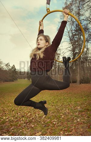 Nice Lady Posing In Autumn Park And Exercising With Steel Hoop