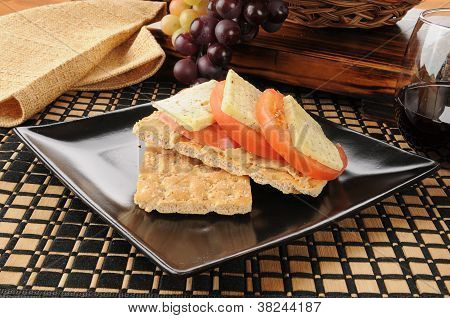 Hummus, formaggio e pomodoro su Crackers