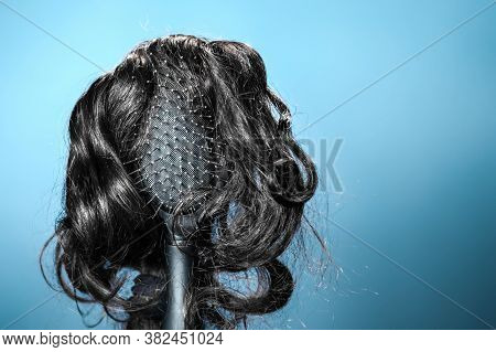 Females Hair. Black Hairbrush With A Black Wig, Looks Like A Womans Head With A Hairstyle. Blue Back