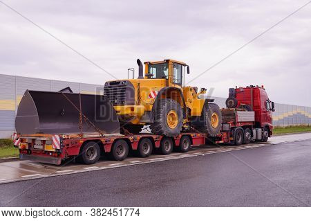 A Truck With A Special Semi-trailer For Transporting Oversized Loads. Transport Of A Huge Bulldozer.