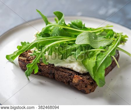 Light Snack, Sandwich With Curd Cheese And Fresh Arugula On A Small Plate