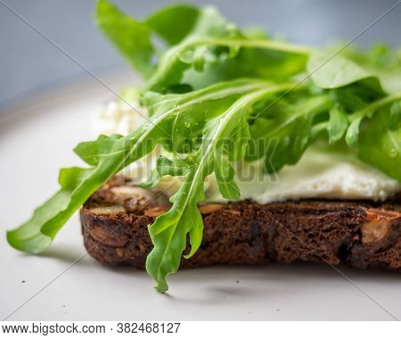 Light Snack, Sandwich With Curd Cheese And Fresh Arugula On A Small Plate On A Gray Background