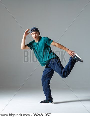 Cool Guy Breakdancer Dancing In Studio Isolated On Gray Background. Breakdance Lessons