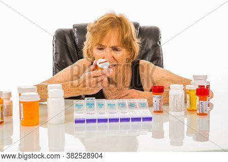 Senior Woman Questioning Pills To Be Put In Her Pill Box
