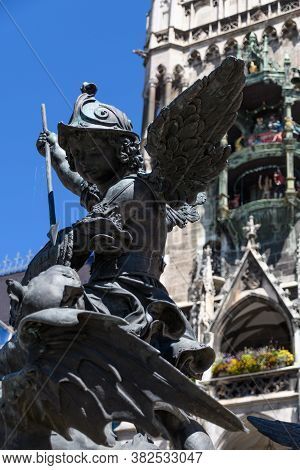 Munich, Germany: Sculpture At The Base Of The Column On Marienplatz. Statue Of A Bronze Putto Killin