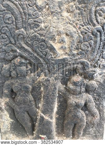 Sculpture Of People Standing Below A Tree. Bas Relief Sculpture Carved In The Stone Wall Of Shiva Te