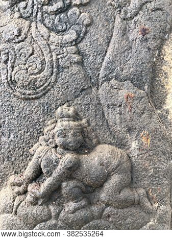Sculpture Of A Baby Lying In The Bottom Of A Tree. Bas Relief Sculpture Carved In The Stone Walls Of