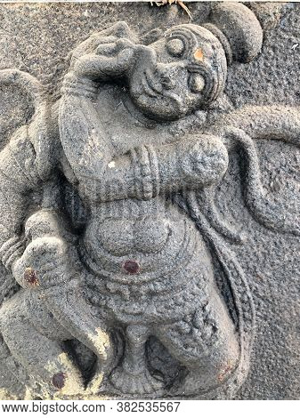God Statue With Weapons In Hand Sculpture. Bas Relief Sculpture Carved In The Stone Walls Of Shiva T