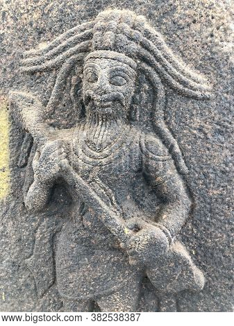Man With A Weapon In Hand Sculpture. Bas Relief Sculpture Carved In The Walls Of Shiva Temple, Tamil