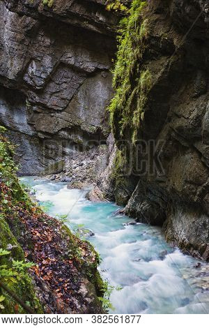A Wild Mountain River With Clear Blue Water Flows Through The Open Area Of The Partnachklamm Gorge I