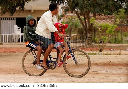 Eunapolis, Bahia / Brazil - August 19, 2010: Three People Are Seen Occupying A Single Bicycle On The